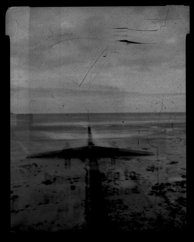 double exposure, BW view of sea overlaid with shot of warning sign.